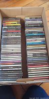 Box containing two rows of approximately 80 CD jewel cases