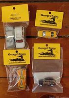 All five sealed HO-scale die-cast vehicles in packaging