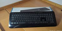 Top view of Microsoft Wireless Keyboard 850 positioned in front of its retail box
