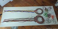 Overall view of two circular beaded collars with fringe and loose beaded strands