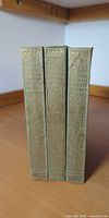 Three gilt-spined volumes upright