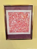 Full view of framed abstract red relief print on wall