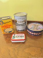 Group shot of four advertising tins on table