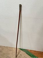 Full length view of swagger stick showing wood shaft and metal tip