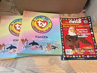 Two Ty Beanie Babies Official Club binders and Coca-Cola International Bean Bag Collection magazine