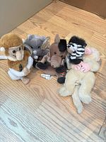 Group shot of five Coca-Cola plush animals on wood floor