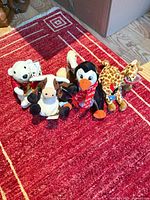 Group shot of five Coca-Cola plush animal ornaments