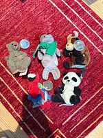 Group shot of all five Coca-Cola plush animals with hang tags