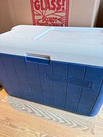 Front view of blue Coleman cooler showing body, logo, and handle recess