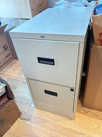 Full view of beige HON two-drawer vertical filing cabinet showing both drawers and overall wear
