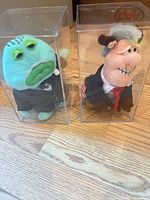 Front view of both Infamous Meanies plush in display cases