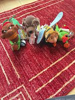 All four Infamous Meanies plush dolls lined up on red rug