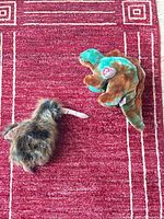 Both plush toys on red rug