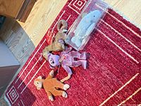 Group shot of four plush toys – monkey, chameleon, bear, dolphin in case