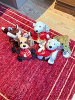 Group shot of all five Coca-Cola plush toys on red rug