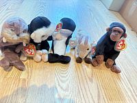 Front view of all five Ty plush animals lined up on wood floor