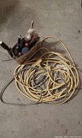 Yellow and grey/black extension cords coiled with box of tools