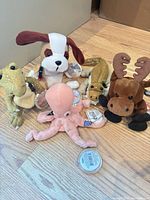 Group shot of five Coca-Cola plush animals showing overall condition and coin tags