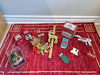 Wide view of all Christmas ornaments and decorations on red rug