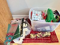 Clear tote filled with assorted gift bags, tissue sheets, and small gift boxes beside additional bags