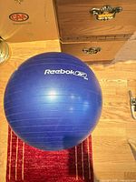 Full view of inflated blue Reebok stability ball on floor