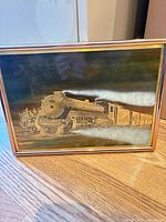 Front view showing full etched metal artwork of steam locomotive in frame