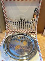 Open box showing 12 forks, cake server, nested trays