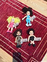 Group shot of four Spice Girls plush dolls on red rug