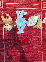 All four Ty Beanie Babies laid out on red rug