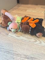 Four Ty Beanie Babies lined up on wood floor