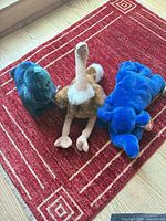 All three Beanie Buddy plush toys on red rug