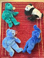 Group shot showing all four Ty Beanie Buddies: teal bear, panda, light blue bear, royal blue elephant