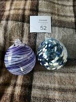 Two glass friendship balls on plaid surface