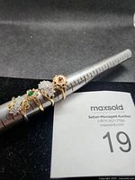 Four costume rings on mandrel showing designs and sizes