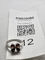 Front view of sterling silver ring with garnet cluster on MaxSold tag