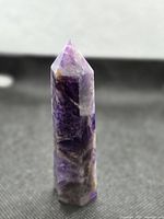 Front view of polished amethyst tower standing upright