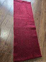 Full view of red alpaca scarf laid flat
