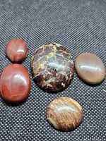 Five polished jasper cabochons on fabric background