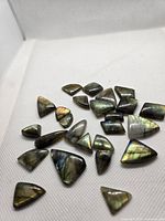 Assorted labradorite cabochons spread on fabric surface