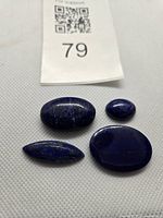 Four lapis lazuli cabochons with lot tag visible