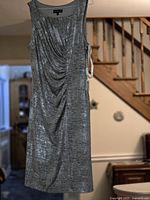 Front view of Jessica metallic silver dress hanging, showing full length and ruching detail