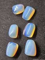 Six polished opalite cabochons on fabric background