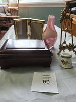 Group shot of all items: jewellery box, three frames, glass vase, brass stand, ceramic jar