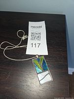 Front view of rectangular stained glass pendant necklace showing glass colors and cord