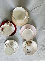 Five teacup and saucer sets laid out on table