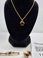 Necklace on display stand with earrings and brooch visible