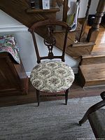 Full view of chair beside staircase showing overall structure and upholstery