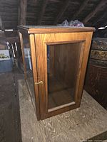 Three-quarter view showing wood frame, glass side panel and latch