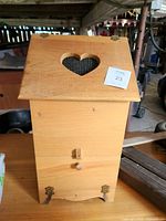 Front view of wooden potato bin with heart cut-out lid and lower door