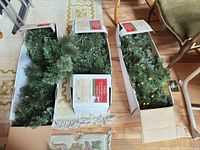 Three boxed green pre-lit garlands on floor